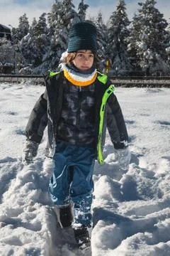Boy walking through deep snow on a sunny winter day Stock Photos