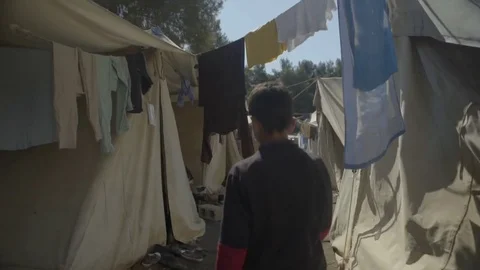 Boy walking through the narrow space between the built tents Stock Footage 77449187