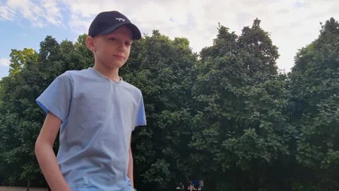 Boy walking through the park Stock Footage 199984101