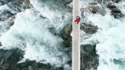 Boy walking through a rope bridge over the river in Norweigan mountains. Stock Footage 85843330