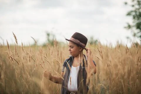 Boy walking through a tall grass field outdoors. Stock Photos