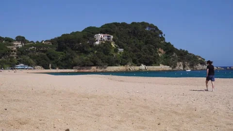 Boy walks alone on the beach looking at the mobile slow motions Stock Footage 182376550