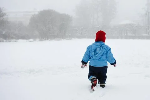 A boy walks alone in the snow Photos