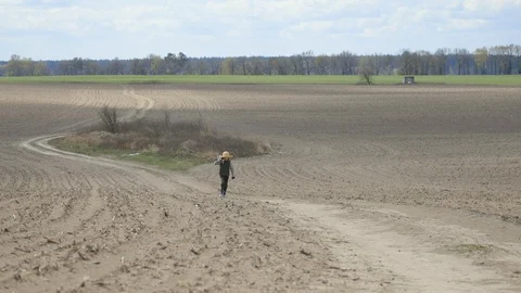 Boy walks along the path through the field Stock Footage 128911202