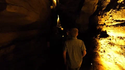 Boy Walks Down Dark Cave Corridor Stock Footage 313467711