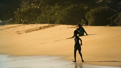A boy walks happily along a sandy beach in Shri Lanka in summer Stock Footage 89159498
