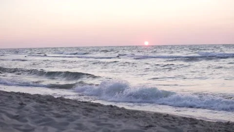 The boy walks quickly along the beach at sunset in the summer Stock Footage 160462593