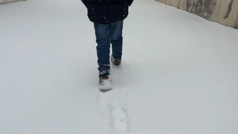 The boy walks on snow Stock Footage 230084829