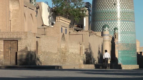 Boy walks through Khiva streets in early morning Video stock 30270691