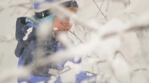 A boy walks through the snow-covered forest Ukraine Stock Footage 57335570