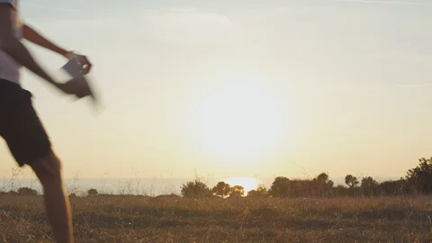 Boy want to be aviator in future and launch paper toy airplane outdoors Stock Footage 129422842