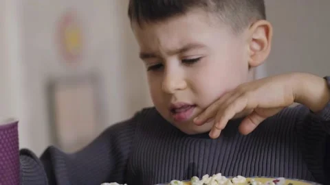 The boy was having dinner, splashing himself trying to drink from the big cup of Stock Footage 202022795