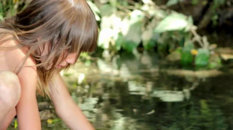 Boy washes his face at a forest stream Stock Footage 24977199