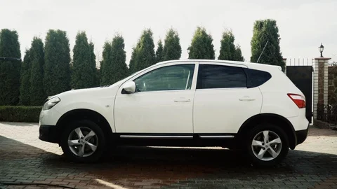Boy washes white car in the yard with professional equipment and on a gyro Stock Footage 129176877