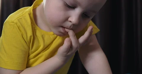 Boy watch cartoon on tablet, bites his nails, bad habit, nervous, captures plot Stock Footage 123354569