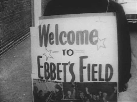 A boy watches the Brooklyn Dodgers playing baseball as well as the Coronation of Stock Footage 74974792