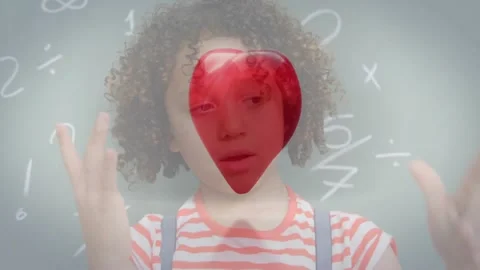 Boy watching heart entering frame and breaking into shards before chalkboard Stock Footage 318239108