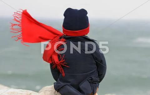 Boy watching the ocean on a stormy, windy day Stock Photos