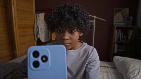 Boy Watching Online Video with Elements of Mature Content in Smartphone Stock Footage 308016449