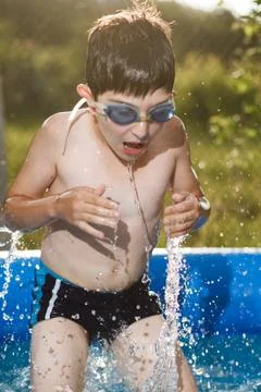 Boy in water with thumbs Stock Photos