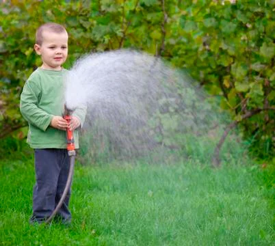 Boy watering the grass Foto stock