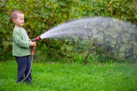Boy watering the grass Stock Photos