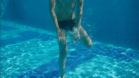 The boy waved his hand underwater in the pool Stock-Footage 79743649