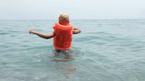 The boy on the waves in a clear, azure sea Stock Footage 111668853