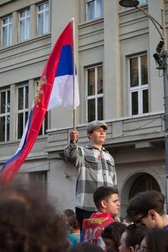 A boy waving a Serbian flag at a protest in Belgrade. Stock Photos