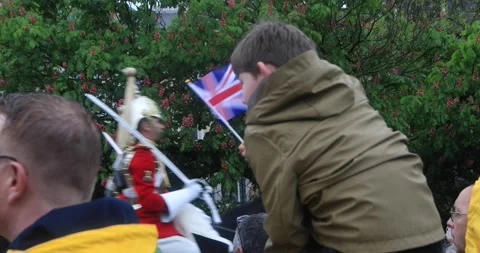 Boy waving Union Jack as royal horse guard passes on coronation day Stock Footage 321017515