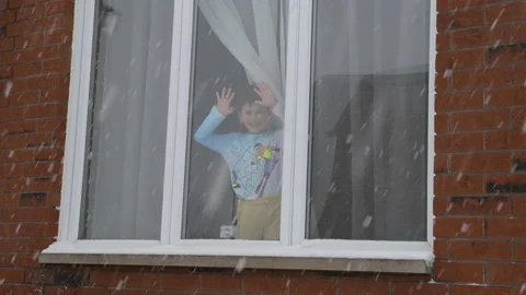 Boy waving from the window, winter day Stock Footage 149385193