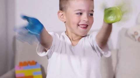 Boy wawing his hands in paint Stock Footage 80638055