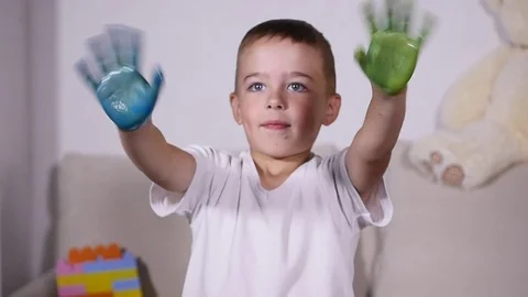 Boy wawing his hands in paint, slow motion Stock Footage 80638114