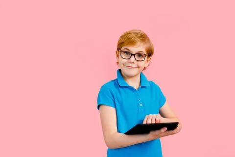 Boy wearing glasses using a tablet on a pink background Stock Photos