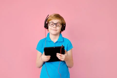 Boy wearing glasses using a tablet on a pink background Stock Photos