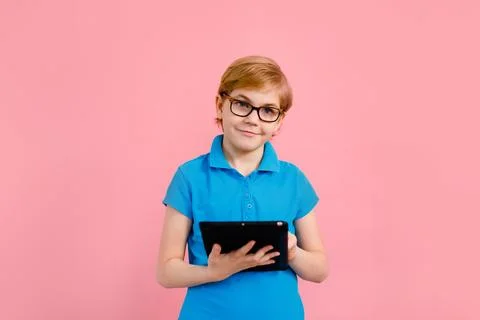 Boy wearing glasses using a tablet on a pink background Stock Photos