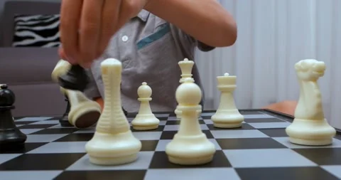 Boy wearing grey tee makes chess turn Stock Footage 212348394