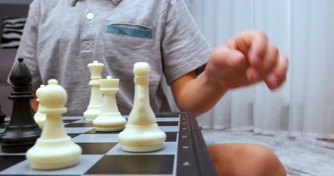 Boy wearing grey tee makes chess turn Stock Footage 212349414