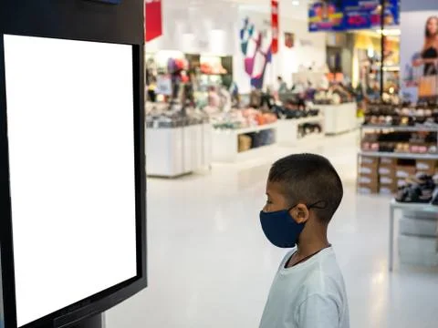 A boy wearing a mask Looking at an empty billboard in the mall Stock Photos