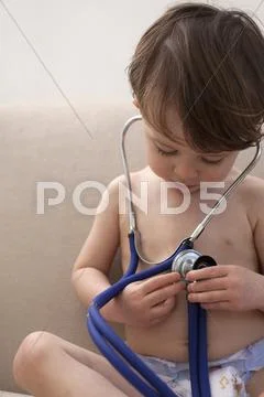 A boy wearing only diapers, playing with a stethoscope Stock Photos