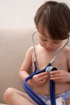 A boy wearing only diapers, playing with a stethoscope Stock Photos
