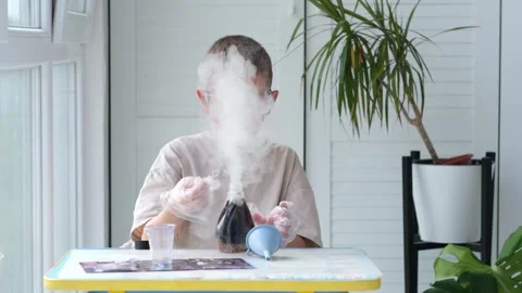 Boy wearing safety glasses performs a chemical experiment. Stock Footage 328505614