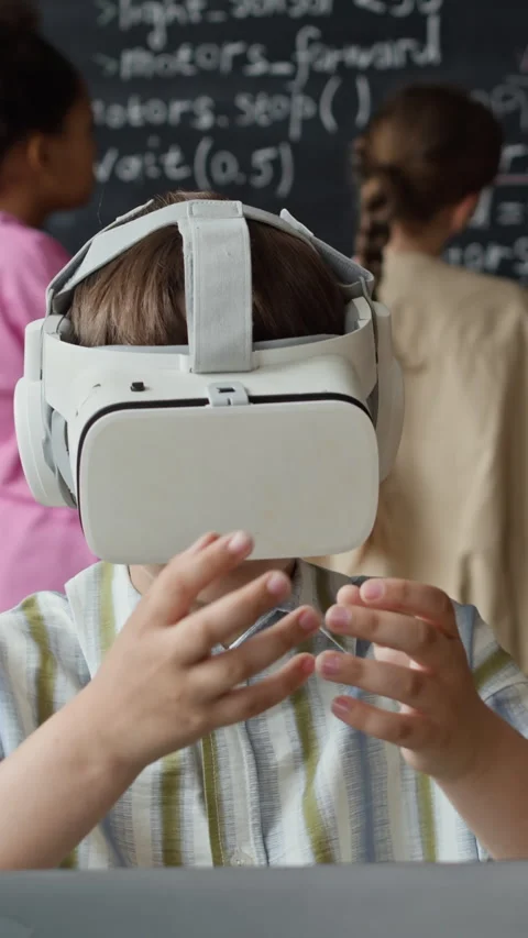 Boy Wearing Virtual Reality Headset Gesturing in Robotics Class Stock Footage 339192033