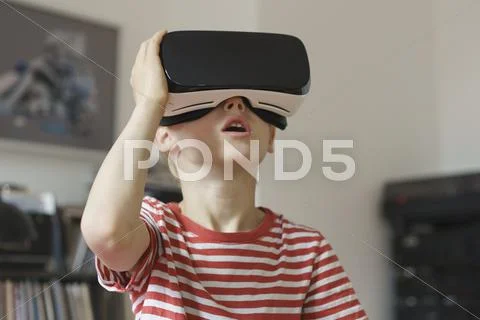 Boy Wearing Virtual Reality Simulator At Home