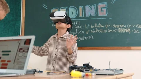 Boy wearing VR headset to enter metaworld while girl coding system. Pedagogy. Stock Footage 275719136