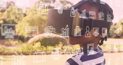 Boy wearing VR headset in park, finance icons appearing and sparking exploration Stock Footage 330959855