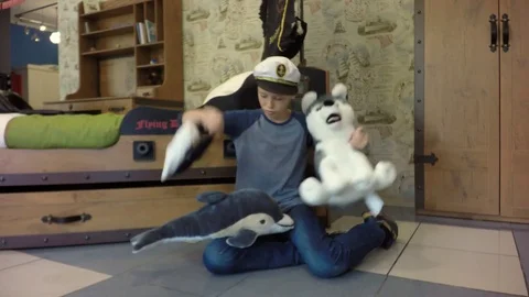 The boy wears a captain's cap. Bed in the form of a pirate ship. Video stock 84264941