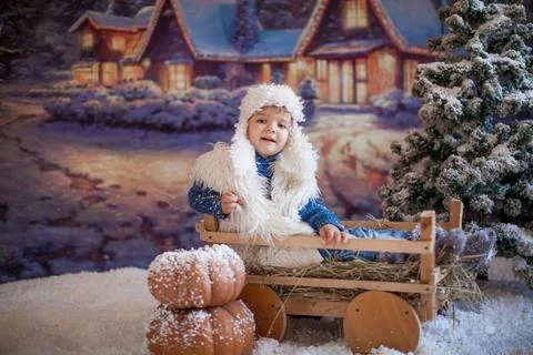 A boy in a white hat and boots on the background of an artificial forest in the Stock Photos