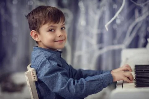 The boy at the white piano Stock Photos
