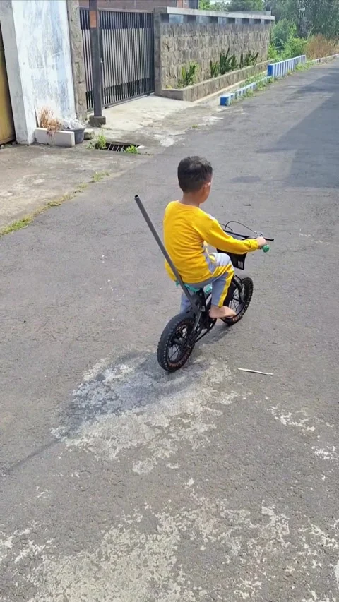A boy who has just learned to ride a two-wheeled bicycle on a residential street Stock Footage 287160444
